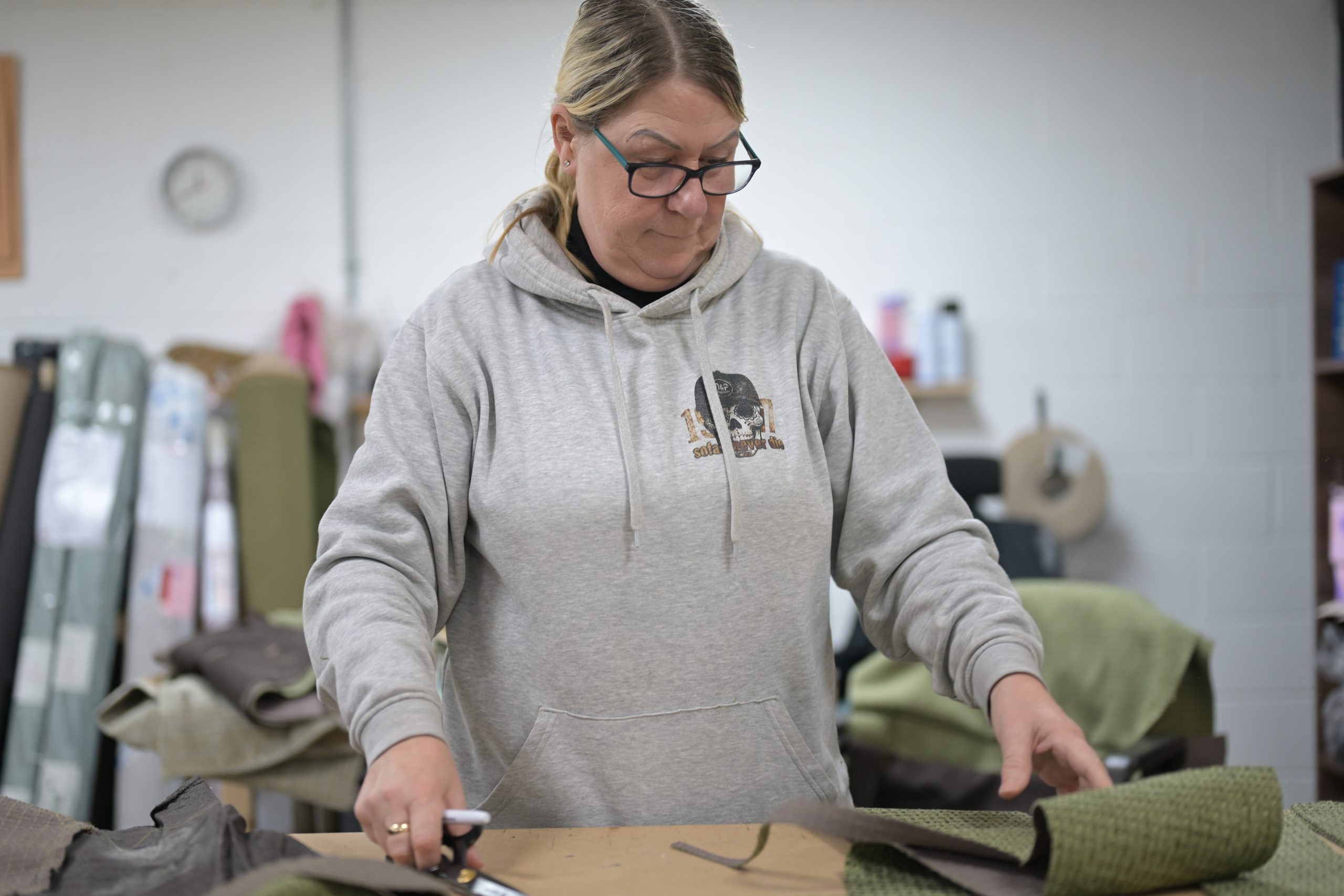 Angela measuring and cutting fabric in the D&P workshop
