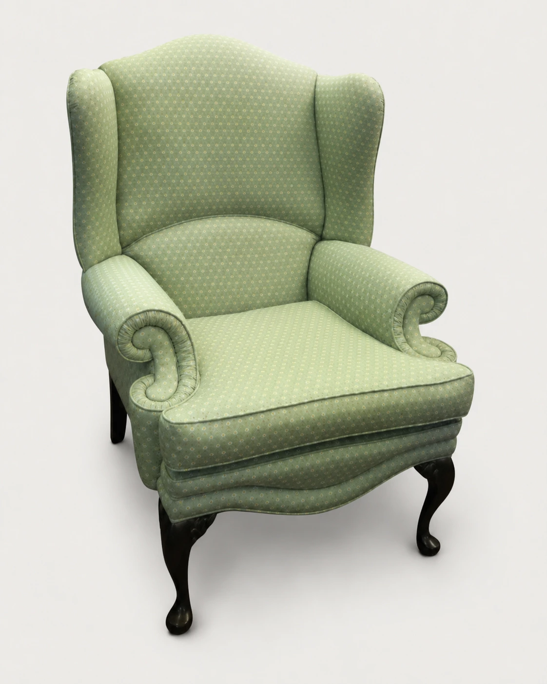 A traditional wingback armchair re-upholstered in soft green fabric by D&P