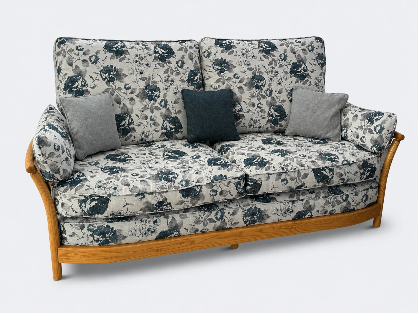 An upholstered sofa with a floral fabric and exposed wooden frame